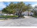 Well-maintained single-Gathering home featuring mature trees, a two-car garage, and manicured landscaping at 11526 Forest Run Ct, Port Richey, FL 34668