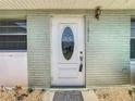 Close-up of the front door featuring an oval glass insert, hardware and the house number at 11917 Bayonet Ln # 11917, New Port Richey, FL 34654