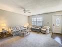 Cozy living room with a ceiling fan, large window, and comfortable furniture arrangement at 11917 Bayonet Ln # 11917, New Port Richey, FL 34654
