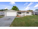 Charming single-story home featuring a well-kept lawn and attached garage at 1721 Kenilworth St, Holiday, FL 34691