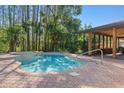 Inviting backyard pool and spa area with a brick paver patio, and a screened-in lanai provide tranquil relaxation at 19019 3Rd Ne St, Lutz, FL 33549
