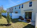 View of townhome backyards, each equipped with patios, chairs, and white fences at 2229 Nancy Lee Dr, Lutz, FL 33558