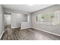 Sunlit living room featuring stylish wood floors and fresh, neutral gray paint at 2608 W Fletcher Ave, Tampa, FL 33618