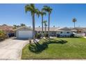 Charming single-story home with a well-manicured lawn, mature palm trees, and an attached garage at 3616 Harborview Ct, New Port Richey, FL 34652