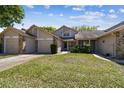 Street view of the property featuring a well-kept lawn, attached garage, and charming two-story home at 6518 Remus Dr, New Port Richey, FL 34653