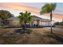 Charming one-story home featuring a well-maintained lawn and beautiful sunset at 7514 Bergamot Dr, Port Richey, FL 34668