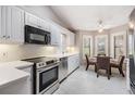 Bright kitchen showcasing stainless steel appliances, white cabinetry, subway tile backsplash and breakfast nook with natural light at 9144 Bassett Ln, New Port Richey, FL 34655