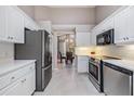 Modern kitchen with stainless steel appliances, white cabinets, and an adjacent dining area with a chandelier at 9144 Bassett Ln, New Port Richey, FL 34655