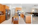 Open kitchen featuring stainless steel appliances, wooden cabinets, and a central island at 11023 Silver Dancer Dr, Riverview, FL 33579