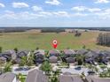 Aerial view of homes in a serene, sprawling community with a big field on the horizon at 11895 Crestridge Loop, New Port Richey, FL 34655