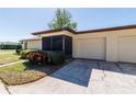 Desirable home features a two-car garage, a screened entry, and manicured bushes enhancing curb appeal at 1223 Queen Anne Dr # B, Palm Harbor, FL 34684