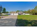 Lovely single-story home with a three-car garage, arched windows, and a lush green lawn at 13045 Marbled Godwit Rd, Weeki Wachee, FL 34614