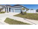 Well-maintained home showcasing a spacious driveway, two-car garage, and a beautifully landscaped front yard at 1436 Gopher Loop, Tarpon Springs, FL 34689