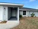 Inviting front entrance featuring a covered porch, modern lighting, freshly painted exterior, and tasteful landscaping at 1713 Walden Ct, Englewood, FL 34224