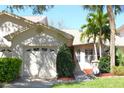 Beautiful home exterior with lush landscaping, manicured lawn, and an attached one-car garage at 2568 W Brook Ln, Clearwater, FL 33761