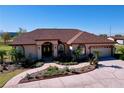 Charming home with a well-manicured lawn, paved walkway, and attached two-car garage at 32826 Knollwood Ln, Wesley Chapel, FL 33545