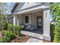 Inviting front porch with seating, decorative pillows, and a welcoming entrance at 3975 Night Star Trl, Odessa, FL 33556