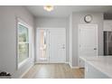 Bright foyer featuring wood-look floors, white trim, and a door to the outside at 5360 Riverwalk Preserve Dr, New Port Richey, FL 34653