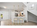 Modern kitchen with white cabinets, stainless steel appliances, and a breakfast bar with stylish pendant lighting at 5360 Riverwalk Preserve Dr, New Port Richey, FL 34653