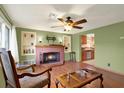 Inviting living room with fireplace, hardwood floors, built-in shelves and view of the kitchen at 5523 Cheyenne Dr, Holiday, FL 34690