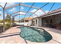 Beautiful screened-in pool area with brick patio, perfect for outdoor relaxation and entertainment at 5737 Wynstone Ln, Zephyrhills, FL 33541