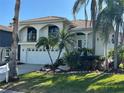Two-story waterfront home with tile roof, balconies, and tropical landscaping at 5956 Seaside Dr, New Port Richey, FL 34652