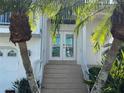 Front entrance to the home featuring a tiled staircase, double doors, and mature landscaping at 5956 Seaside Dr, New Port Richey, FL 34652