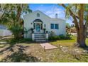 Charming home featuring a unique tiled staircase, arched entryway, and well-maintained front yard landscaping at 6244 Warren Ave, New Port Richey, FL 34653