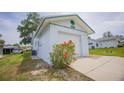 A well-maintained white home with an attached garage and landscaped with blooming flowers at 8121 Casuarina Dr, Port Richey, FL 34668