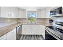 Modern kitchen with white cabinets, stainless steel appliances, and granite countertops at 8626 White Springs Dr, New Port Richey, FL 34655