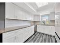 Bright kitchen featuring white cabinets, granite countertops, and stainless steel appliances at 8626 White Springs Dr, New Port Richey, FL 34655