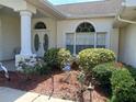 Close-up of a home's front entrance with decorative plants and an ADT security sign, offering curb appeal and security at 8630 Ne Coral Creek Loop, Hudson, FL 34667