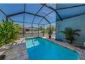 Relaxing screened-in pool area with refreshing blue water, brick pavers, and lush plants for a private oasis at 10623 Marsha Dr, New Port Richey, FL 34655