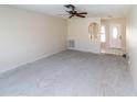 Bright living room features a ceiling fan and a view into entry hallway, ready for your personal touch at 11001 Peppertree Ln, Port Richey, FL 34668