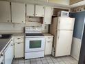 Kitchen area with white appliances and dated cabinetry awaiting an upgrade at 11130 Carriage Hill Dr # 1, Port Richey, FL 34668