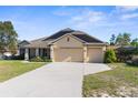 Inviting single-Gathering home boasting a spacious driveway and an attached three-car garage at 12450 Fish Cove Dr, Spring Hill, FL 34609