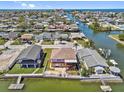 Aerial view of waterfront home with private boat docks and waterway access to gulf, and mature landscaping at 13820 Plumosa Ave, Hudson, FL 34667