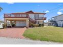Two-story home with a two-car garage, balconies, landscaped lawn, and a stairway to the upper floor at 13820 Plumosa Ave, Hudson, FL 34667