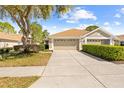 Inviting home exterior with a well-manicured lawn and a spacious three-car garage, offering ample parking at 14471 Sterling Run, Spring Hill, FL 34609