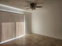 Inviting bedroom with neutral walls, tile flooring, ceiling fan, and sliding glass door at 14656 Wake Robin Dr, Brooksville, FL 34604