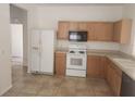 Functional kitchen features tile flooring, white appliances, and light wood cabinetry at 14656 Wake Robin Dr, Brooksville, FL 34604