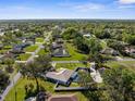 Expansive aerial view shows lush neighborhood with verdant landscaping, swimming pools, and tiled roofs at 15193 Copeland Way, Brooksville, FL 34604