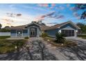 Charming single story home features a lovely blue exterior and well maintained front yard with mature landscaping and walkway at 15193 Copeland Way, Brooksville, FL 34604