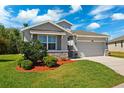 Charming single-Gathering home with a two-car garage, stone accents, lush landscaping, and a well-manicured lawn at 15793 Midnight Dove Ct, Odessa, FL 33556