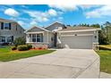 Charming single-Gathering home with a two-car garage, stone accents, lush landscaping, and a well-manicured lawn at 15793 Midnight Dove Ct, Odessa, FL 33556
