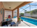 Relaxing covered patio featuring an in-ground swimming pool and outdoor furniture at 1783 Wood Brook St, Tarpon Springs, FL 34689