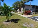 Condo building with green grass and tropical landscaping at 19505 Quesada Ave # Bb-103, Port Charlotte, FL 33948