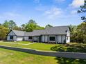 Charming two-story exterior of a home with a beautiful front yard, landscaping, and retaining wall at 23298 Christian Cir, Brooksville, FL 34601