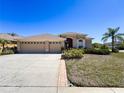 Charming one-story home with a well-maintained lawn, mature trees, and a three-car garage at 2634 Ravendale Ln, Holiday, FL 34691