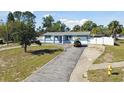Charming single Gathering home, front view with driveway, featuring mature trees and inviting curb appeal at 6250 Vermont Ave, New Port Richey, FL 34653